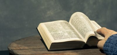 Young man sitting at a table reading the Holy Bible